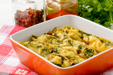 Italian cuisine - pasta shells stuffed with spinach, ricotta and baked with tomatoes.