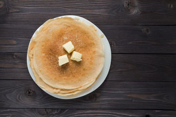 pancakes with butter on a wooden background