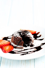 Chocolate fondant with strawberry on blue wooden table