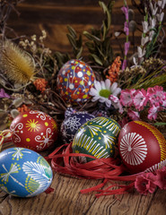 Fototapeta na wymiar Easter background. the composition colored Easter eggs with flowers and blooming willow on the wood background