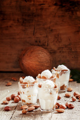 Ice cream with peanut sauce, hazelnuts and almonds in glasses, s