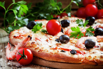 Pizza with seafood and black olives, selective focus