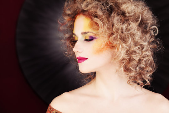 Glamorous Woman. Fashion Makeup and Blonde Curly Hair