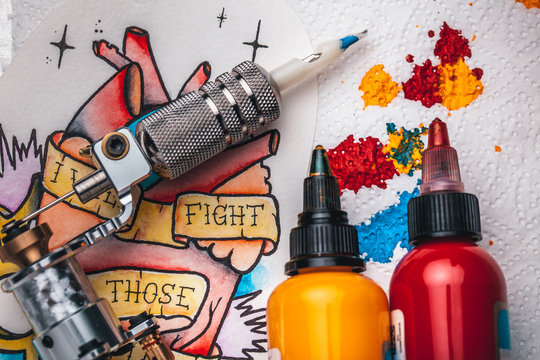 Naklejki Replacement supplies for tattoo in sterile packages, sketches, inks and a tattoo machine on the white background of old boards