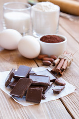 Ingredients for making chocolate chip cookies on a wooden background