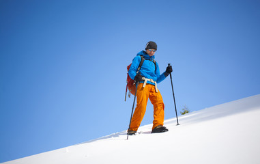 Fototapeta na wymiar The climber goes on the snow slope.