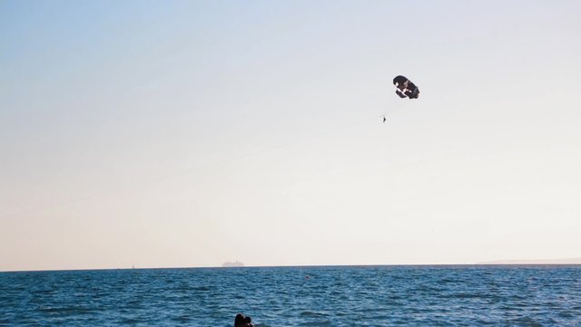 The boat pulls the parachute at sea