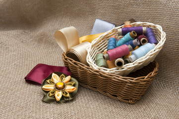 Fototapeta na wymiar Coils with colorful threads in a wicker basket