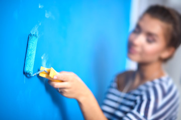 Happy beautiful young woman doing wall painting