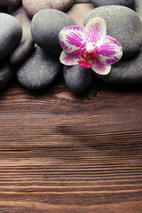 Fototapeta na wymiar Spa stones and orchid on wooden background