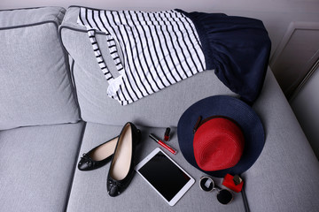 Composition of woman's fashion look on a gray couch