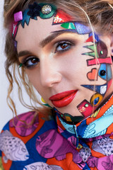  Beautiful woman with bright creative fantasy multicolored makeup, geometric shapes.
