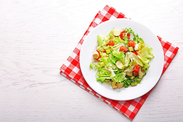 Tasty salmon salad on light wooden background