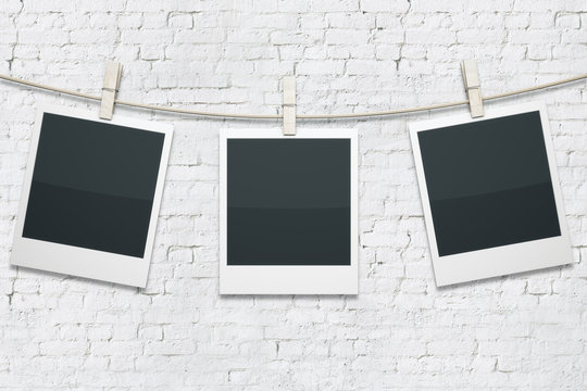 Polaroids on white brick