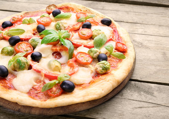 Delicious pizza with cheese and vegetables on wooden background