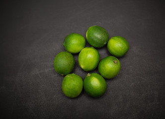 Great amazing closeup view of fresh appetizing green limes on dark grey background