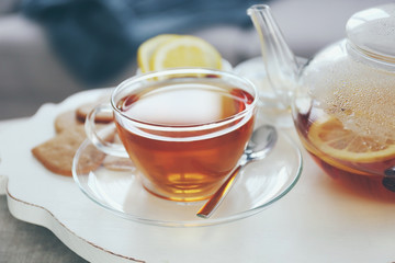 Tea set with hot tea and breakfast on a white wooden mat on the table