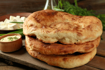 Fresh fried bread and other products on wooden table closeup