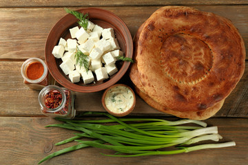 Fresh fried bread and other products on wooden background