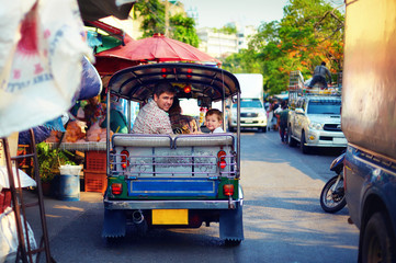 Fototapeta premium happy tourist family travel through the asian city on tuk-tuk taxi
