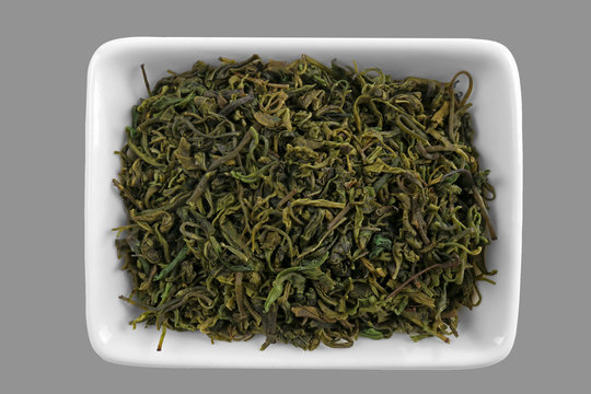 Kuding tea leaves in bowl, isolated on white