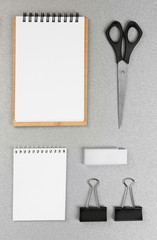 Office set with white sheets of paper, notebooks and stationery on grey background