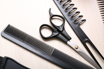 Barber set with tools on light wooden table, close up