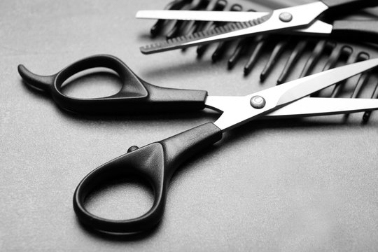 Barber set with comb and scissors on grey background, close up