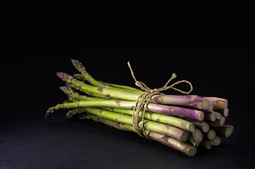 bunch of fresh green asparagus on a dark background, copy space