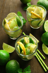 Fresh mojito drinks with lime, lemon and mint on wooden table