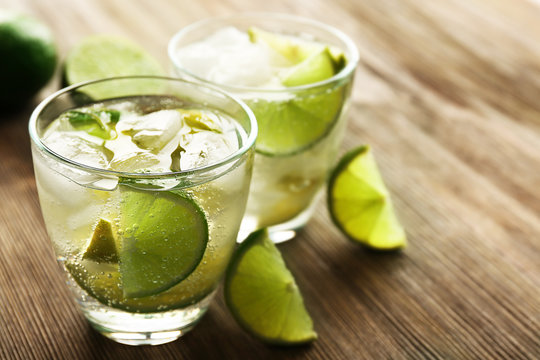 Mojito drink with lime on wooden table