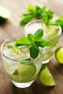 Mojito drink with lime and mint on wooden table