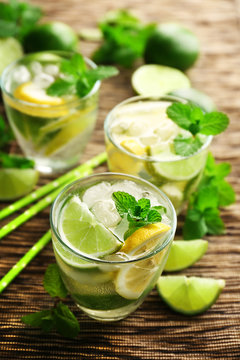 Three mojito drinks with lime, lemon and mint, closeup