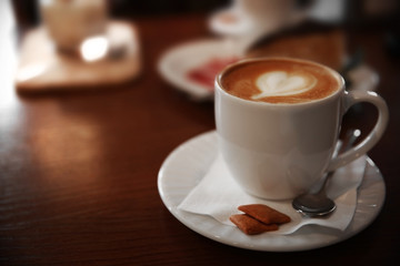 Cup of cappuccino on table in cafe