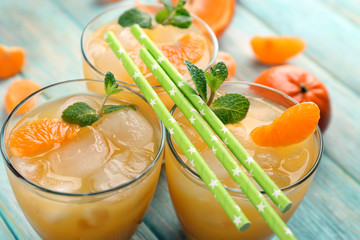 Fresh cocktails with ice, mint and tangerines on the wooden table, close up