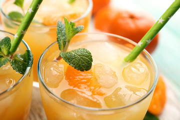 Fresh cocktails with ice, mint and tangerines on a white wooden board, close up