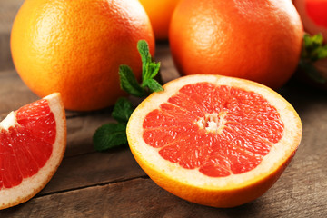 Naklejka na ściany i meble Sliced grapefruits with mint on wooden background, close up