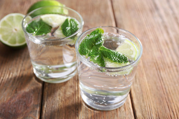 Fresh cocktails with mint, ice and lime on wooden table background