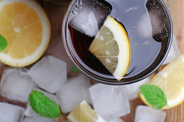 Glass of cola with cubes of ice and lemon , closeup