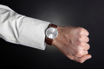 Modern watch on a businessman's wrist over black background