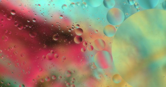 Oil drops floating in water over a colorful underground with oil painting effect. Shot on RED