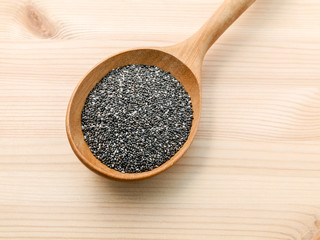 Nutritious chia seeds in wooden spoon for diet food ingredients.