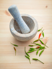 Fresh Chillies on white wooden background with mortar and pestle
