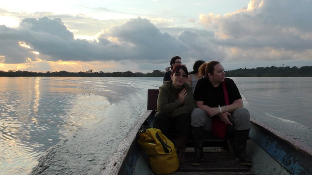 Experience the breathtaking beauty of Cuyabeno Wildlife Reserve in Ecuador as a group of tourists embark on a mesmerizing sunset ride in a motorized canoe.