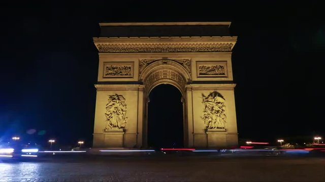 Timelapse shot of car traffic by the Triumphal Arch of the Star illuminated at night. One of the most famous monuments in Paris, France