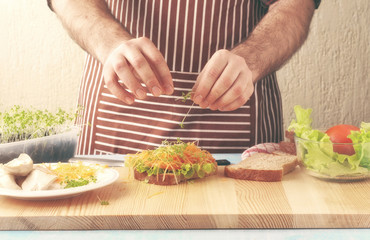 man cooking chicken sandwich