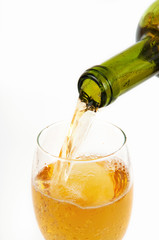 Pouring white wine from bottle into the wineglass