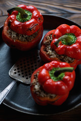 Baked bell peppers with meat and rice filling in a frying pan