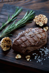 Close-up of grilled asado steak with garlic, salt and rosemary