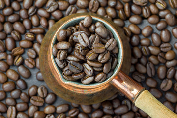 Fototapeta premium Fragrant coffee beans in copper cezve, top view, close up